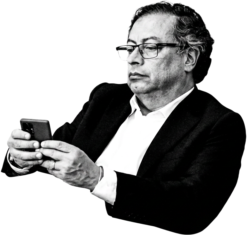 Gustavo Petro sentado, en blanco y negro, revisando su celular